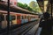 Young attractive girl is taking pictures of a painted bright train in the subway on her smartphone.