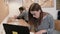 Young attractive girl is using a laptop, working with documents, making notes in the modern startup office