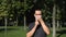 A young attractive guy waves his hand in greeting and takes off his protective medical mask.