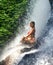 Young attractive and happy 30s woman with fit body practicing yoga wet under tropical paradise waterfall stream in meditation and