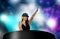 Young attractive and happy Asian Chinese DJ woman remixing using deejay gear and headphones at night club with lights background