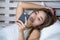Young attractive and happy Asian woman lying relaxed on bed using internet social media app in mobile phone smiling sending text o