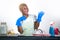 Young attractive and happy black african american woman cleaning home kitchen putting blue washing rubber gloves smiling cheerfu