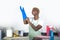 Young attractive and happy black african american woman cleaning home kitchen putting blue washing rubber gloves smiling cheerfu