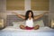 Young attractive and happy black African American woman at home bedroom doing yoga meditation and body relaxation exercise stretch