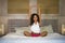 Young attractive and happy black afro American woman at home bedroom doing joga meditation and body relaxation exercise stretching