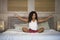 Young attractive and happy black latin American woman at home bedroom doing yoga meditation and body relaxation exercise stretchin