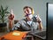 Young attractive and happy man with yellow headphones sitting at home office desk working with laptop computer having fun listenin