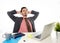 Young attractive Latin businessman in suit and tie working at office computer desk leaning back on the chair looking relaxed