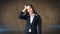 Young attractive longhair businesswoman in suit stressed and holding her head in fatigue, studio background