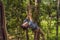 Young attractive man in adventure rope park in safety equipment