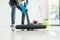 Young attractive man is cleaning vacuum commercial cleaning equipment on floor at home helping wife