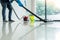 Young attractive man is cleaning vacuum commercial cleaning equipment on floor at home helping wife