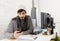 Young attractive man in hipster beanie and trendy style businessman working in stress