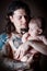 Young attractive man holding a newborn baby studio shot