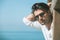 Young attractive man with sunglasses looking out over the sea during the summer.