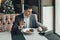 A young and attractive man uses his phone while eating veal tenderloin in ashes with grilled vegetables in an indoor