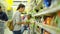 Young Attractive Mom and Little Child Buying Food in a Supermarket. Beautiful Woman with Cute Girl Standing Near Shelf