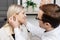 A young attractive otolaryngologist doctor gives a consultation to a female patient. A doctor explains how to wear a hearing aid