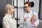 A young attractive otolaryngologist doctor shows a model of the human head and tells the patient about the structure of the