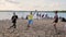 Young attractive people joyfully play valleyball on cute sunny summer beach