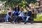 Young and attractive people are sitting on a bench in ghetto street.