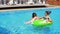 Young attractive people swimming on inflatables on the pool party. Pretty women and men having a pool party. Slowmotion