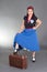 Young attractive pinup girl posing with suitcase