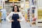 Young attractive positive girl seller on the background of the shopping center. Saleswoman at construction super store. Copy space