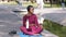 Young attractive positive plus size African woman waiting for training, relaxing after work out outdoors, holding bottle