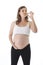 Young attractive pregnant woman holding her big belly in one hand and eating pickle happy
