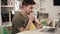 Young attractive programmer thinking hard about something while sitting beside his laptopin a classroom.