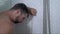 Young attractive sad and depressed man in the shower leaning against the wall thoughtful