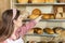 Young attractive saleswoman brings fresh bread from the shelf. Recommended traditional family bakery with multi