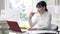 Young attractive slim woman sitting at table with laptop thinking. Portrait of concentrated Caucasian businesswoman