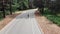 Young attractive sportive caucasian woman in pink jersey and black helmet is riding her bike in the summer forest. Aerial Drone sh