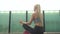 Young, attractive and sporty blond girl meditating outdoor. Healthcare and lifestyle.