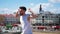 Young attractive stylish man with tattoos freestyle dancing on the top point in the centre of the city - pointing at the