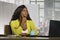 Young attractive and thoughtful black afro American business woman working at office computer desk looking away thinking and