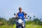 Young attractive tourist afro American black woman riding motorbike happy in beautiful Asia countryside along green rice fields s