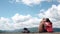 Young attractive tourist couple hugging and kissing on background of amazing blue sky