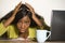 Young attractive unhappy and exhausted black African American woman working lazy on Monday at office computer desk feeling overwhe