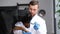 A young attractive veterinarian examines a large black dog in a modern veterinary office.