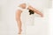 Young attractive woman in Ardha Chakrasana pose, white color bac