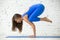 Young attractive woman in Bakasana pose, white studio background