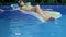 Young attractive woman bathes in a pool on a mattress. view from above. woman on vacation swims in her pool