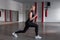 Young attractive woman in black leggings in the sports t-shirt doing exercises with dumbbells in hands in the gym.