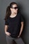 Young attractive woman in black t-shirt and sunglasses studio shot,  mock up
