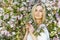 Young attractive woman in blooming spring trees