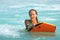 Young attractive woman bodyboards on surfboard with nice smile